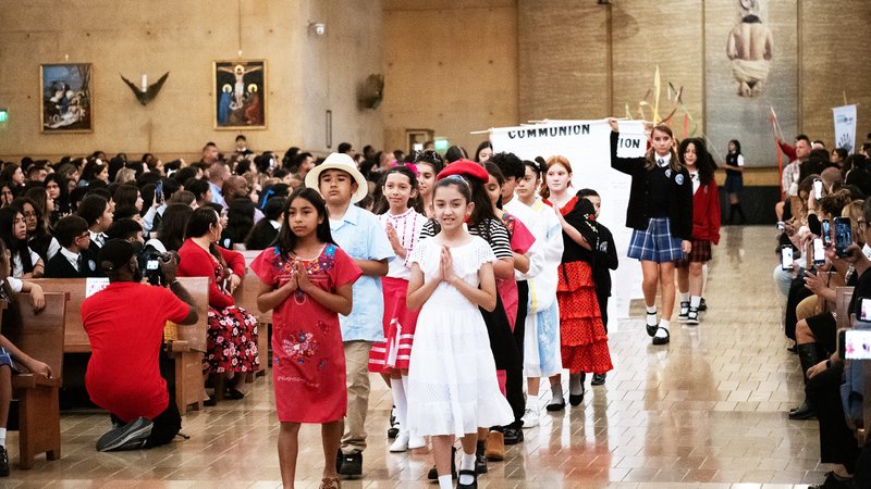 Students process in holding signs to begin the annual Missionary Childhood Association Youth Appreciation Mass on Oct. 16. (Victor Alemán)