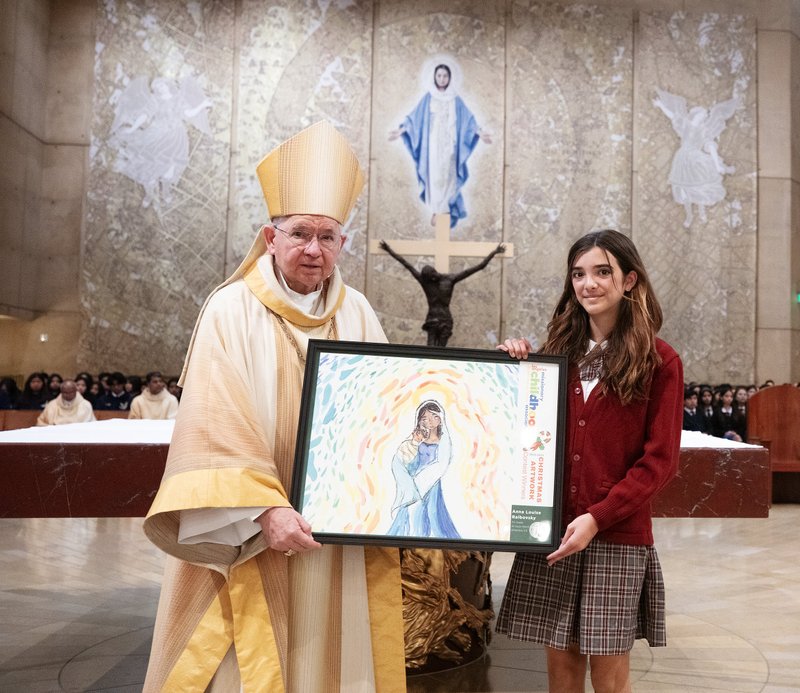 Anna Louise Ralbovsky of All Souls World Language Catholic School in Alhambra poses with Archbishop José H. Gomez after being honored for her artwork during the annual Missionary Childhood Association Youth Appreciation Mass on Oct. 16. (Victor Alemán)