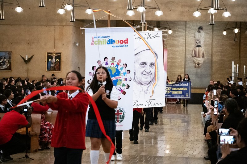 Students process in holding signs to begin the annual Missionary Childhood Association Youth Appreciation Mass on Oct. 16. (Victor Alemán)