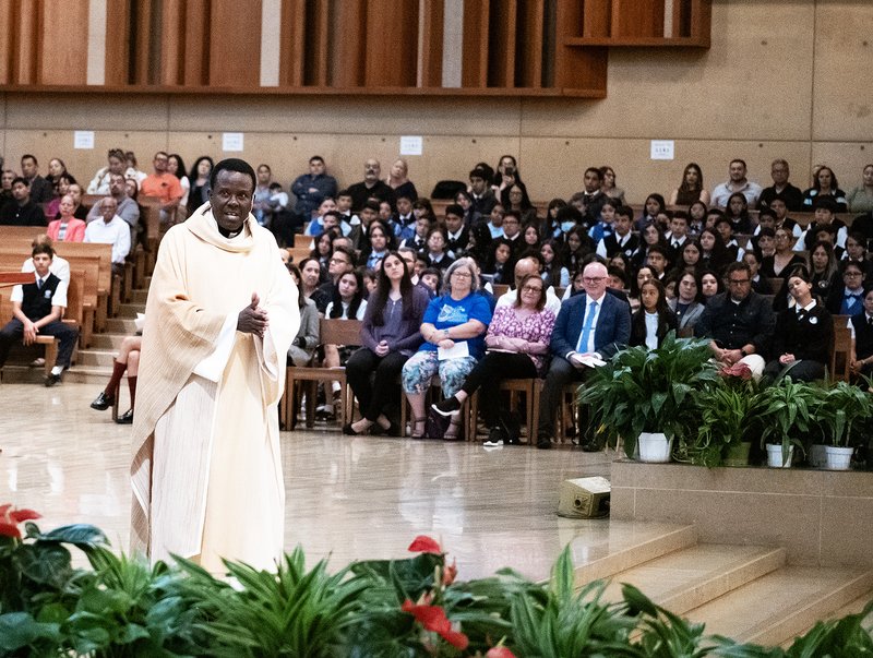 Father Frederick Byaruhanga, a priest originally from the Diocese of Kabale in Uganda and now a chaplain for the VA Greater Los Angeles, addresses the crowd during his homily for the annual Missionary Childhood Association Youth Appreciation Mass on Oct. 16. (Victor Alemán)