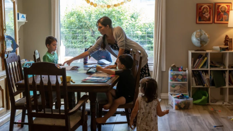 Maureen McKinley helps her children through some study exercises in her family's dining room in Phoenix. McKinley and her husband, Matt, home-school their five children and offer the older children a curriculum that includes Latin. (Jake Kelly via CNA)