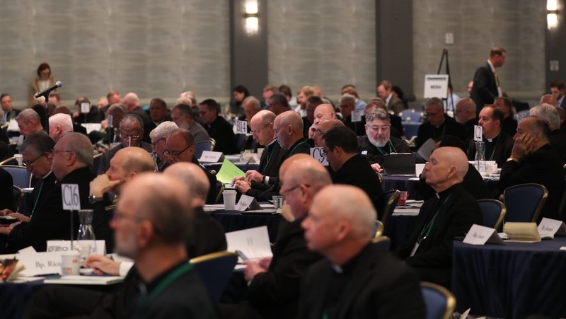 Bishops look over paperwork at the end of a Nov. 12 session of the U.S. bishops’ fall general assembly in Baltimore. (OSV News/Bob Roller)