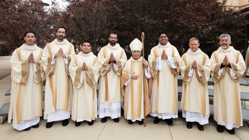 The seven men being ordained as transitional deacons pose with Auxiliary Bishop Brian Nunes following their Ordination Mass at the Cathedral of Our Lady of the Angels on Nov. 23. The newly ordained deacons are Paul Collins, Michael Croghan, Joseph Cruz, Johndy Gonzales, Jorge Moncada, Christian Morquecho, and Quoc Vo. (Victor Alemán)