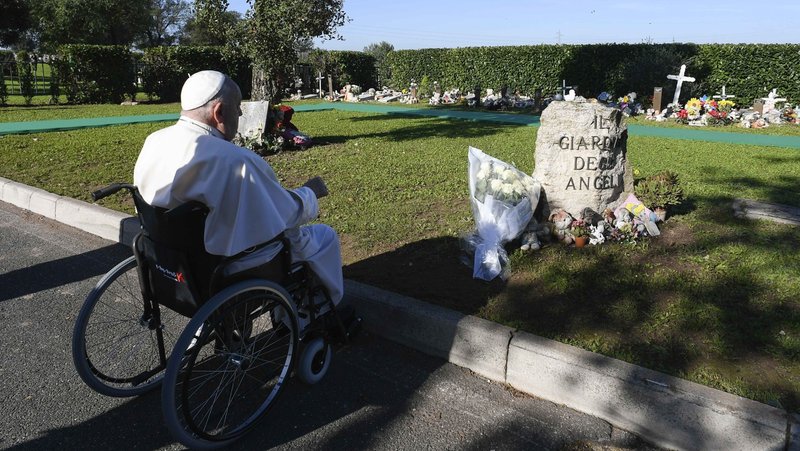 Pope Francis pauses to pray after leaving white roses at the section of Rome's Laurentino cemetery set aside for miscarried infants on the feast of All Souls, Nov. 2, 2024. (CNS photo/Vatican Media)