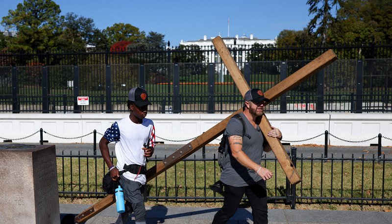 A man carries a large wooden cross near the White House in Washington D.C. on Nov. 5, 2024, Election Day. (OSV News photo/Daniel Cole, Reuters)
