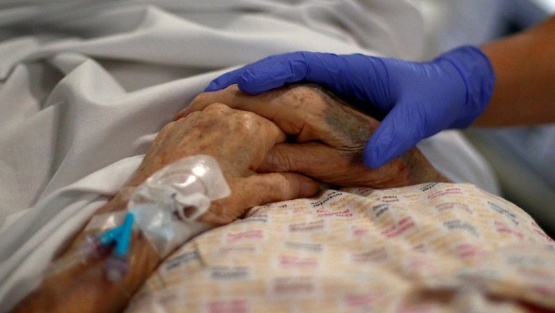 A health care worker comforts a patient at a hospital in Blackburn, England, May 14, 2020. Churches and faith groups across the United Kingdom have condemned a bill to allow physician-assisted suicide and stepped up efforts to block its Nov. 29, 2024, approval by members of Parliament. (OSV News photo/Hannah McKay, pool via Reuters)