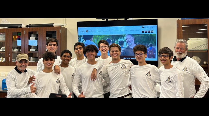 Mark Fredette, left, St. Francis High School’s Religious Studies teacher, and William Heinen, right, AP Biology teacher, pose with the winning team of the school’s Knight Skies Program, which sent their experiment into space. (St. Francis High School)