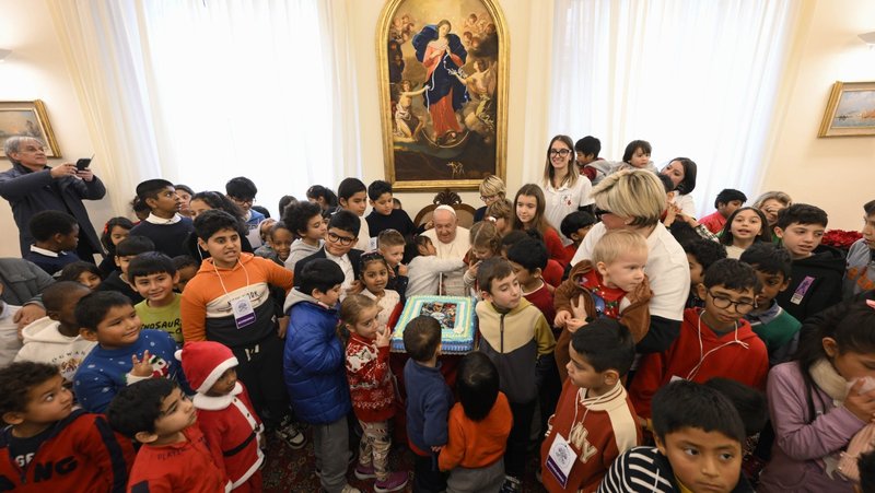 A few days after his 88th birthday, Pope Francis and his birthday cake are surrounded by children from the Vatican's Santa Marta pediatric clinic as they visit him in his Vatican residence Dec. 22, 2024. (CNS photo/Vatican Media)