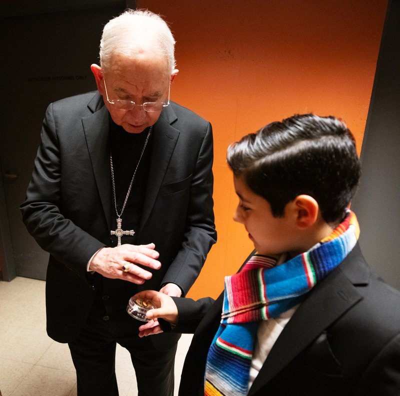 Archbishop José H. Gomez blesses the rosary of Sebastian Gonzalez, 12, after he helped recite the rosary at the Las Mañanitas vigil celebrating Our Lady of Guadalupe on Dec. 11. (Victor Alemán)