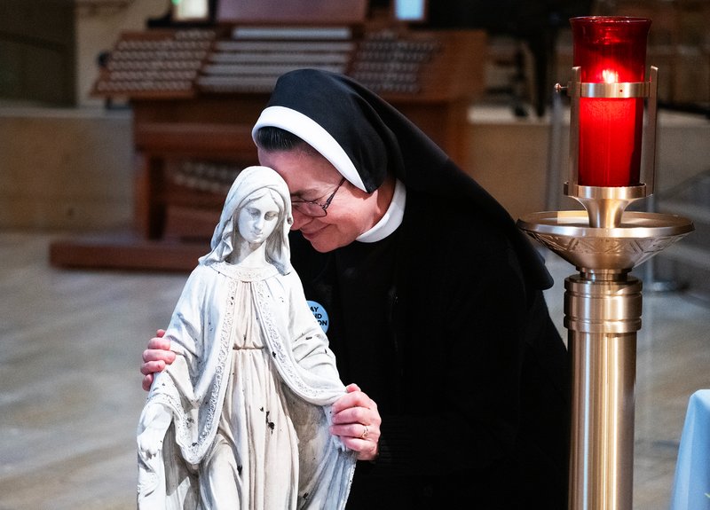 A religious sister embraces the Virgin Mary statue that survived the Eaton Fire during the OneLife LA celebration at the Cathedral of Our Lady of the Angels on Jan. 18. (Victor Alemán)