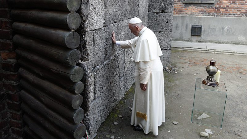 Pope Francis touches the death wall at the Auschwitz Nazi death camp in Oswiecim, Poland, in this July 29, 2016, file photo. The pope said remembering the Holocaust and its victims is not only an "expression of humanity" but also makes people aware that such horrors may happen again. The pope's comments came at his general audience as he commemorated International Holocaust Remembrance Day Jan. 27. (CNS photo/Paul Haring)