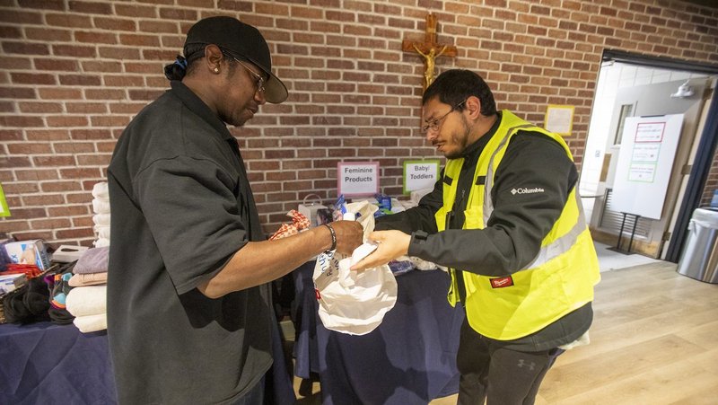 Volunteer Abel Garcia, right, helps distribute essential daily items to a man displaced by wildfires at the "Eaton Fire Parish Response" at St. Philip the Apostle Church in Pasadena, Calif., Jan. 10, 2025. Fires raging in the Los Angeles area reduced some 12,000 structures to ash and rubble, killed at least 11, displaced thousands of others and spread over an area larger than the size of San Francisco. (OSV News photo/Ringo Chiu)