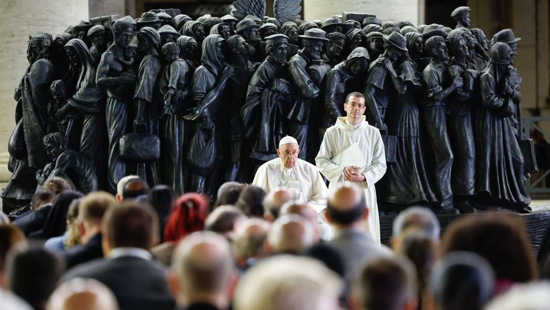 Pope Francis shares a moment of silence with members of the assembly of the Synod of Bishops at the end of a prayer for migrants and refugees in St. Peter's Square at the Vatican Oct. 19, 2023. The service took place around "Angels Unawares," a sculpture by Canadian Timothy Schmalz, depicting a boat with 140 figures of migrants from various historical periods and various nations. (CNS photo/Lola Gomez)