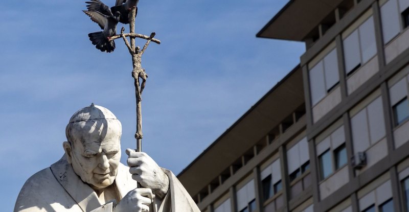 Two pigeons alight to rest on the crosier of a statue of St. John Paul II outside Rome's Gemelli hospital Feb. 23, 2025, where Pope Francis is being treated for double pneumonia. (CNS/Pablo Esparza)