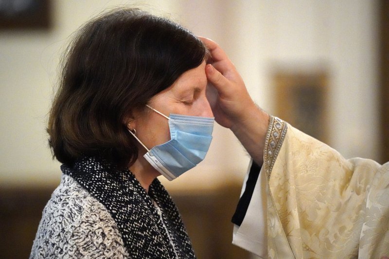 A priest anoints a woman’s forehead with the oil of the sick during a healing Mass at his parish in this 2022 file photo. (CNS/Gregory A. Shemitz)