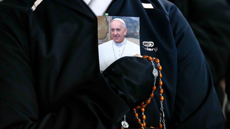 A person holds a rosary and a photo of Pope Francis as people gather in St. Peter’s Square at the Vatican to recite the rosary for Pope Francis with Cardinal Robert F. Prevost, prefect of the Dicastery for Bishops, March 3, 2025. (CNS photo/Pablo Esparza)