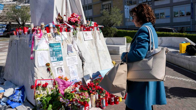 A woman stands near a statue of St. John Paul II outside Rome’s Gemelli hospital March 6, 2025, looking at messages and drawings for Pope Francis, who has been hospitalized there since Feb. 14, receiving treatment for double pneumonia. (CNS photo/Lola Gomez)