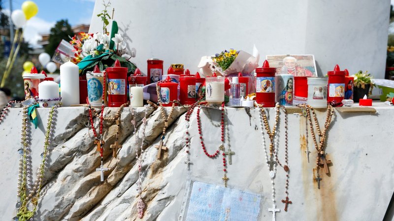 Devotional items are seen at the base of a statue of St. John Paul II outside of Rome's Gemelli hospital March 16, 2025. (CNS photo/Justin McLellan)