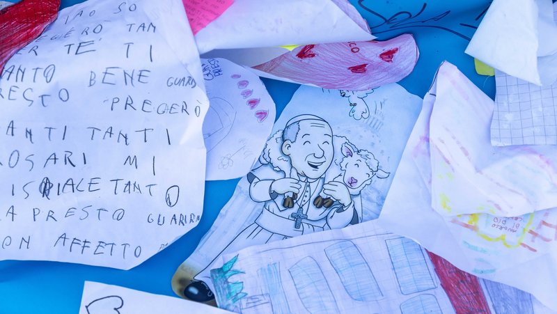 Drawings and messages are seen at the base of a statue of St. John Paul II outside of Rome's Gemelli hospital March 19, 2025. (CNS photo/Pablo Esparza)