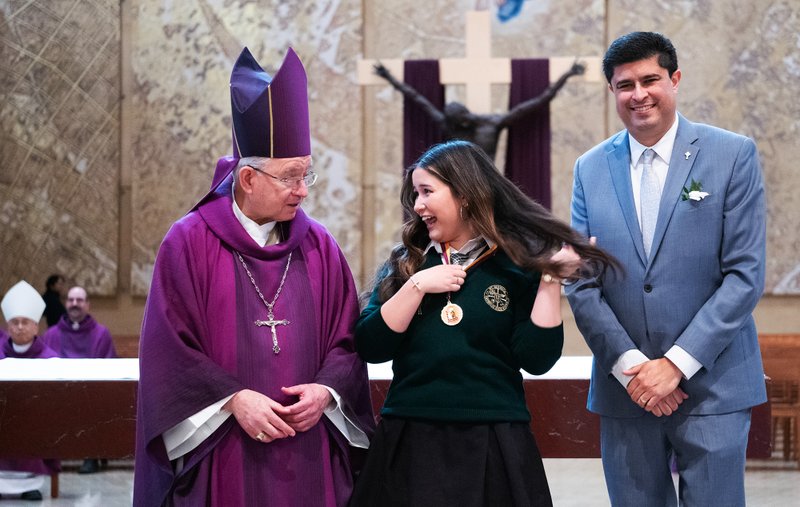 Lucia Lopez of Saint Monica Preparatory in Santa Monica has a quick laugh with Archbishop José H. Gomez before receiving her medal from Superintendent of Catholic Schools Paul Escala at the Christian Service Awards Mass on March 18. (Victor Alemán)