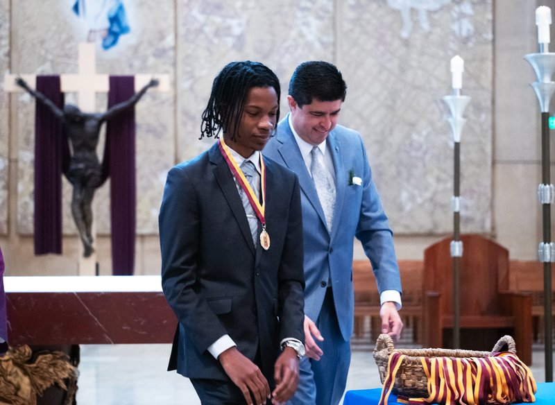 Josiah Hankerson of Verbum Dei Jesuit High School in Watts receives his medal from Paul Escala, right, superintendent of Catholic schools, at the Christian Service Awards Mass on March 18. (Victor Alemán)