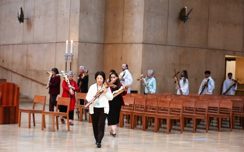 Volunteers bring out crosses for attendees to kiss and venerate during a Good Friday liturgy at the Cathedral of Our Lady of the Angels on April 18. (Victor Alemán)