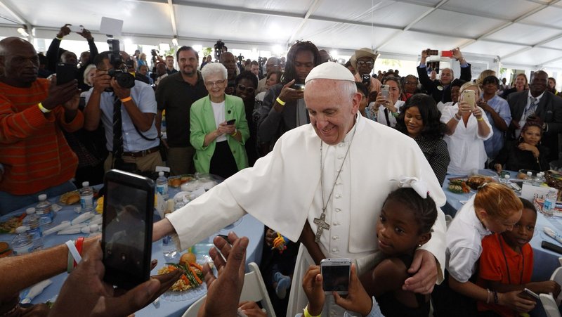 A girl hugs Pope Francis as he visits with people at St. Maria's Meals Program of Catholic Charities in Washington Sept. 24, 2015. (CNS/Paul Haring)