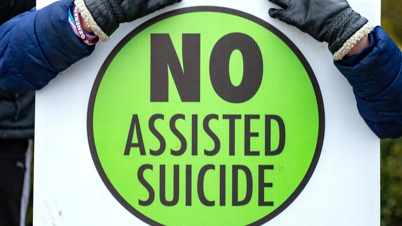 A person is pictured in a file photo holding a sign against physician-assisted suicide. As many as 18 states will consider bills to legalize the practice in 2025, according to the group Death With Dignity, which supports physician-assisted suicide. But a smaller number of states have advanced such bills in 2025, including Illinois and Delaware. (OSV News photo/Kevin J. Parks, Catholic Review)