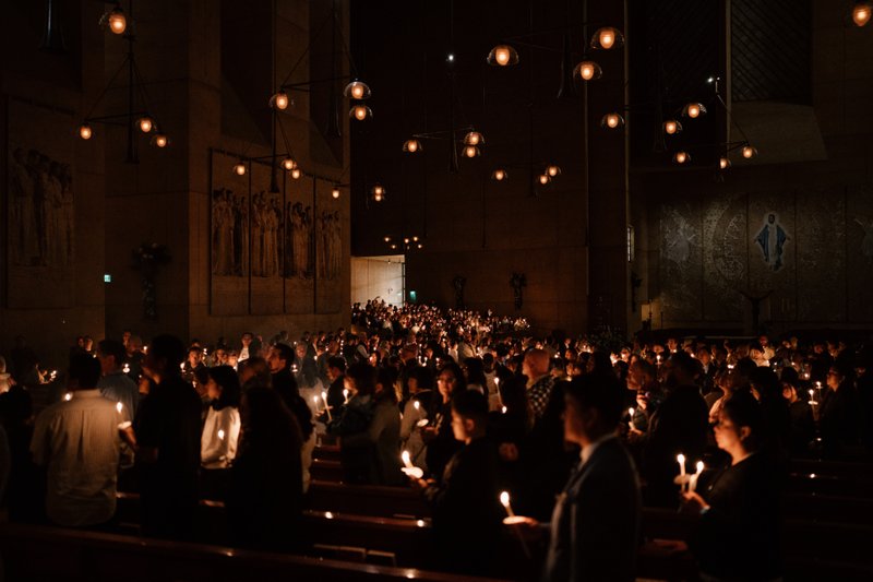 Attendees carry candles at the Cathedral of Our Lady of the Angels for the Easter Vigil Mass on April 19. (Peter Lobato)