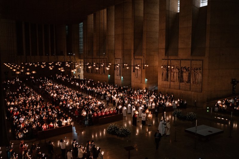 Attendees carry candles at the Cathedral of Our Lady of the Angels for the Easter Vigil Mass on April 19. (Peter Lobato)