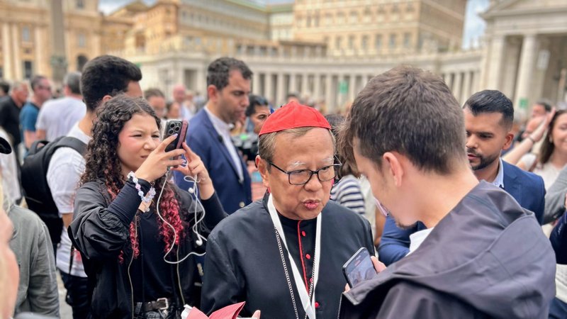 Cardinal Ignatius Suharyo Hardjoatmodjo of Indonesia blesses a pilgrim’s religious articles while taking questions from the media in St. Peter’s Square May 5, 2025. (Pablo Kay)