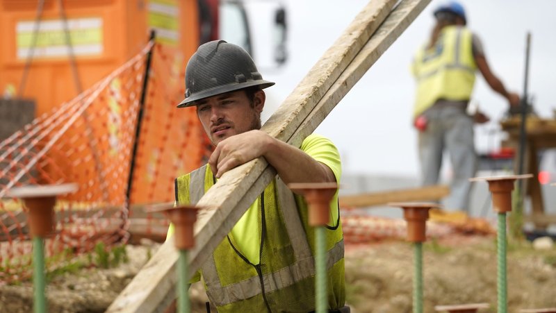 A worker carries lumber at a highway construction site in Stony Brook, N.Y., Aug. 30, 2022. (OSV News photo/CNS file, Gregory A. Shemitz)