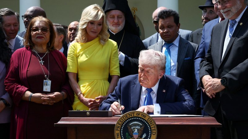 Surrounded by faith leaders, U.S. President Donald Trump signs an executive order on the "Establishment of the Religious Liberty Commission" during the National Day of Prayer in the Rose Garden at the White House in Washington May 1, 2025. Also pictured in yellow is Paula White, senior adviser to the White House Faith Office. (OSV News photo/Evelyn Hockstein, Reuters)