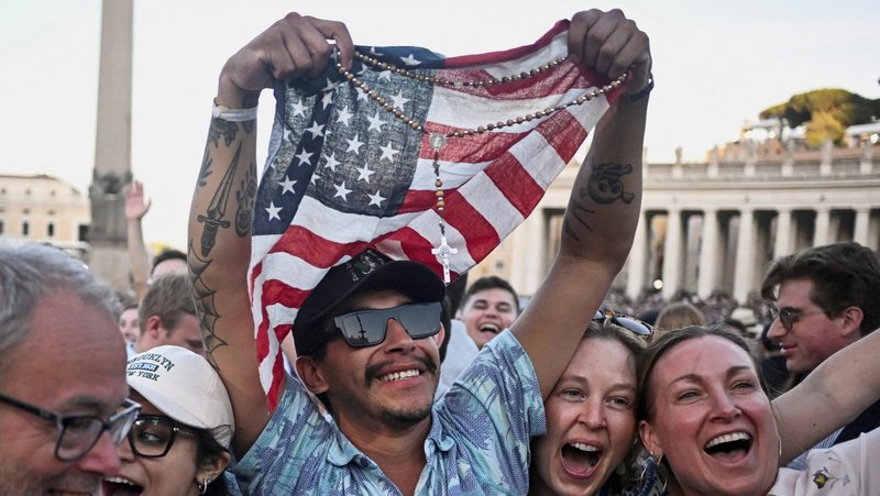 A man holding a rosary and U.S. flag reacts as Cardinal Robert Francis Prevost, who has chosen the papal name Leo XIV, appears on the central balcony of St. Peter's Basilica at the Vatican May 8, 2025, following his election during the conclave. He is the first American pope in history. (OSV News photo/Dylan Martinez, Reuters)