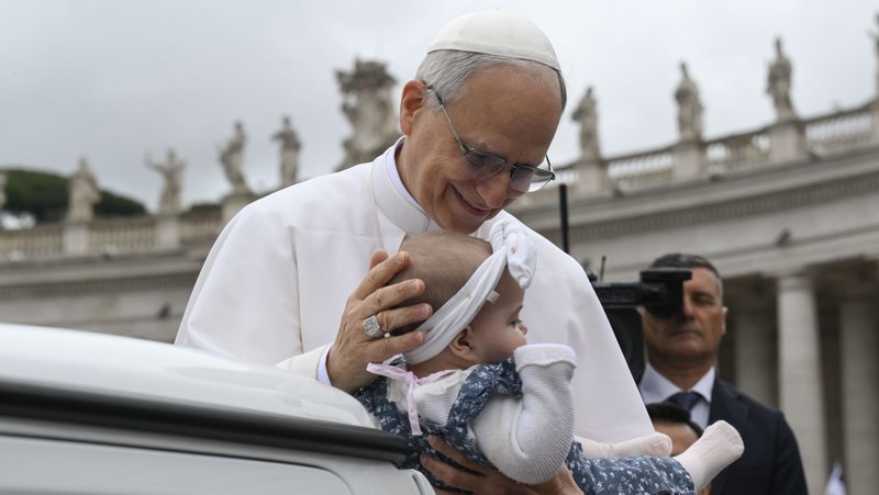 Pope Leo XIV blesses a baby as he rides in the popemobile around St. Peter's Square at the Vatican before his first weekly general audience May 21, 2025. (CNS photo/Vatican Media)