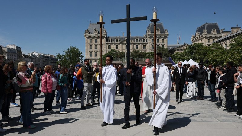 A volunteer carries a cross during a Good Friday procession in front of Notre Dame Cathedral in Paris April 18, 2025. With France poised to vote on a controversial "assisted dying" bill, the country's Catholic bishops have launched an unprecedented public campaign urging Catholics to speak out against the bill. Twelve bishops of the Paris region prayed in Notre Dame Cathedral on May 21 for the bill to be rejected. Debate continues in Parliament through May 25 before the May 27 vote. (OSV News photo/Gonzalo Fuentes, Reuters)