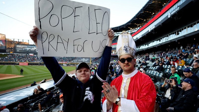 Chris Foss holds up a sign as David Hughes Jr. dressed like a pope gestures on the day of a match between the Chicago White Sox and the Miami Marlins, at the Rate Field baseball stadium, in Chicago, May 9, 2025. (OSV News photo/Carlos Osorio, Reuters)