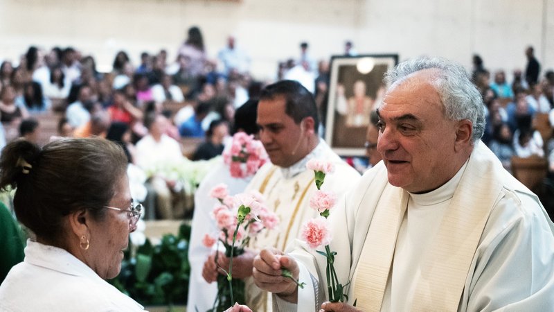 Msgr. Antonio Cacciapuoti, right, and Father Peter Saucedo give roses to mothers during a Mother’s Day Mass at the Cathedral of Our Lady of the Angels May 11. Cacciapuoti is the cathedral’s pastor, while Saucedo is in residence there. (Victor Alemán)
