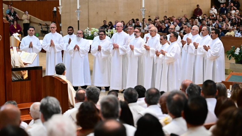 The 18 men ordained as permanent deacons stand in front of Archbishop José H. Gomez during the ordination Mass at the Cathedral of Our Lady of the Angels on June 7. (John McCoy)
