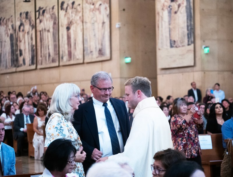 Father Paul Collins blesses his parents during the ordination Mass at the Cathedral of Our Lady of the Angels on May 31.(Victor Alemán)