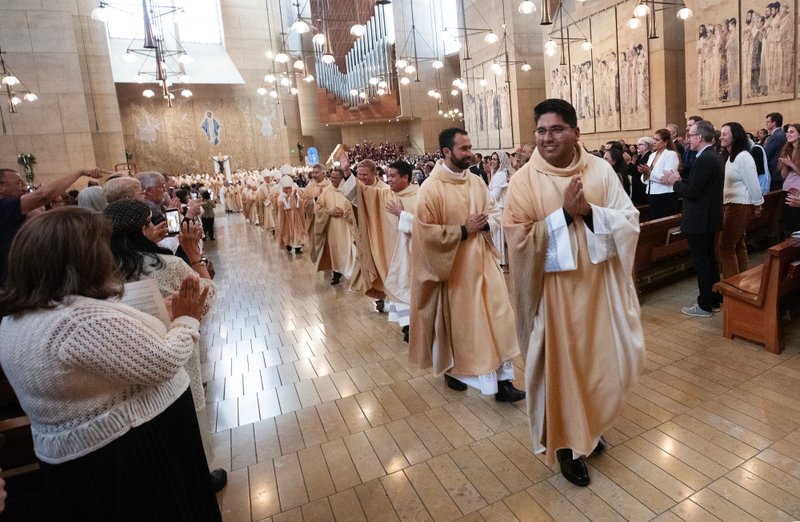 The eight newly ordained priests receive applause processing out following the ordination Mass at the Cathedral of Our Lady of the Angels on May 31. (Victor Alemán)