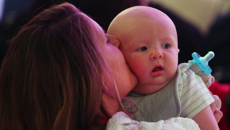 A mother kisses her baby July 19, 2024, during the revival night of the National Eucharistic Congress at Lucas Oil Stadium in Indianapolis. (OSV News/Bob Roller)
