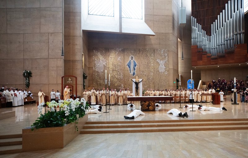 The eight men prostrate themselves at the altar during the ordination Mass at the Cathedral of Our Lady of the Angels on May 31. (Victor Alemán)