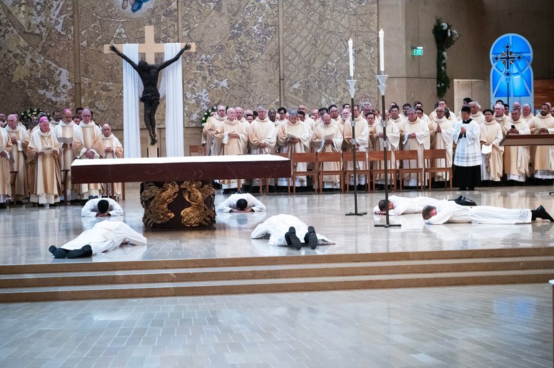 The eight men prostrate themselves at the altar during the ordination Mass at the Cathedral of Our Lady of the Angels on May 31. (Victor Alemán)