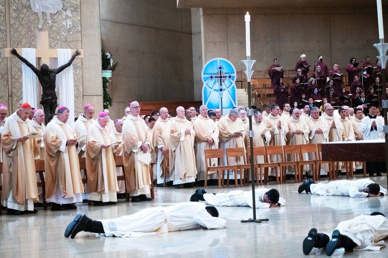 The eight men prostrate themselves at the altar during the ordination Mass at the Cathedral of Our Lady of the Angels on May 31. (Victor Alemán)