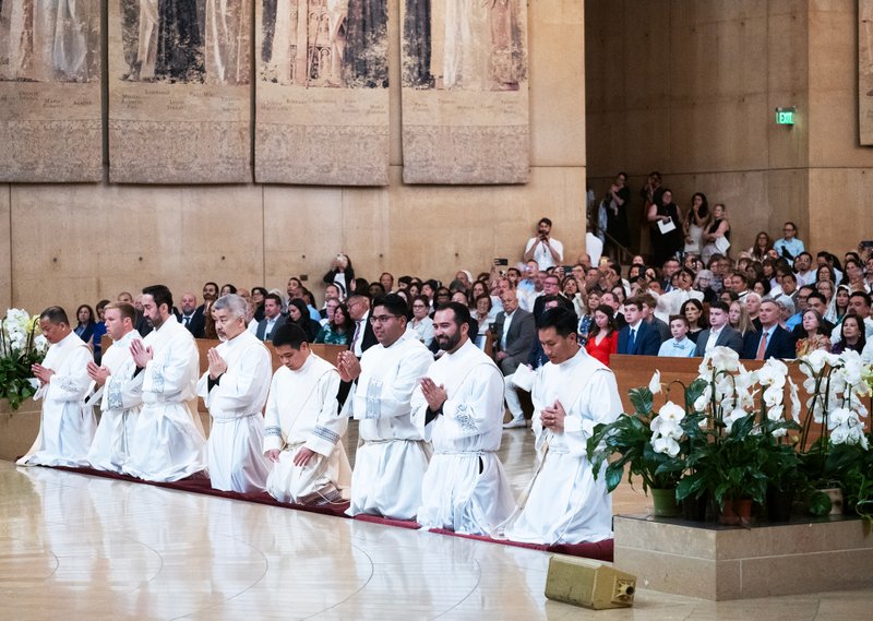 Moments before becoming priests, the eight men of the LA Archdiocese’s Class of 2025 kneel in prayer during their May 31 ordination Mass at the Cathedral of Our Lady of the Angels. (Victor Alemán)