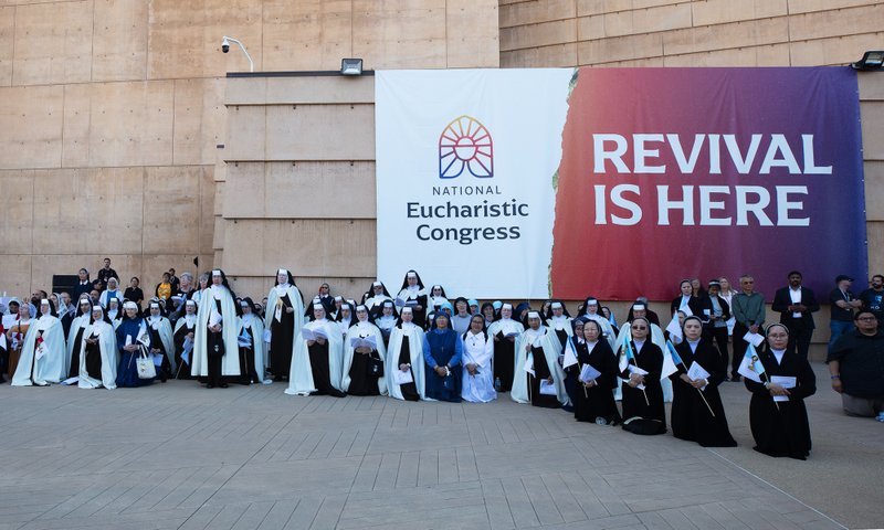 Attendees of the Corpus Christi Mass at the Cathedral of Our Lady of the Angels on June 22 stand in the outdoor plaza under a banner for the National Eucharistic Revival. (Victor Alemán)