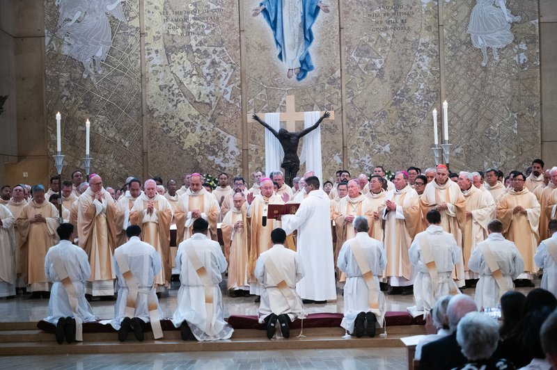 The eight men receive prayers during the ordination Mass at the Cathedral of Our Lady of the Angels on May 31. (Victor Alemán)