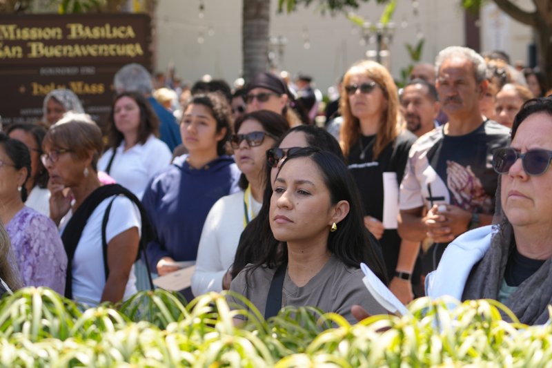 Worshippers stand outside Mission Basilica San Buenaventura during a Eucharistic procession on June 20 during the National Eucharistic Pilgrimage’s final weekend. (Katie Trejo)