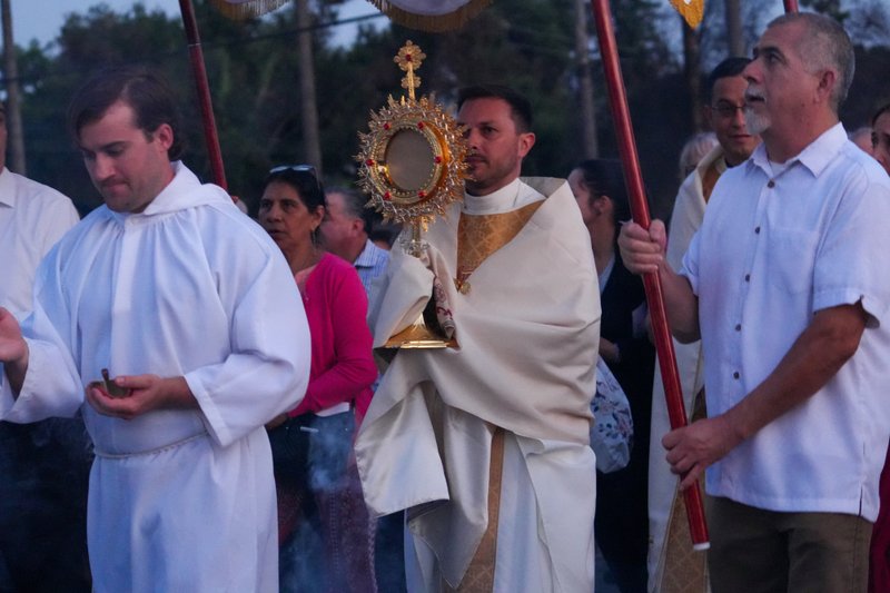 Father Parker Sandoval carries the monstrance during a Eucharistic procession as part of the National Eucharistic Pilgrimage that traveled through the streets of Altadena that were burned in the Eaton Fire on June 20. (Katie Trejo)
